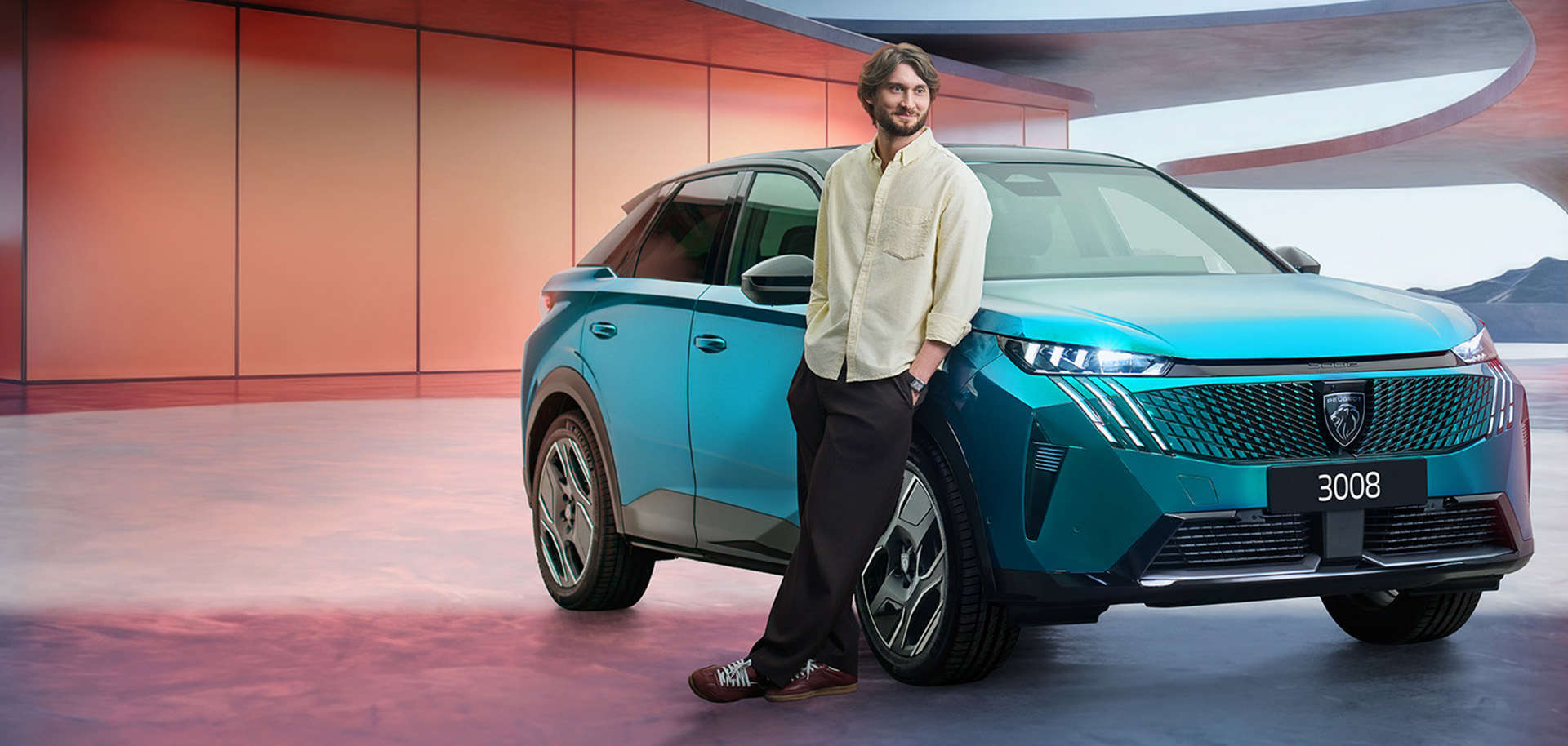 Художній керівник хору «Гомін» біля кросовера Peugeot 3008 синього кольору, вигляд спереду з правого боку