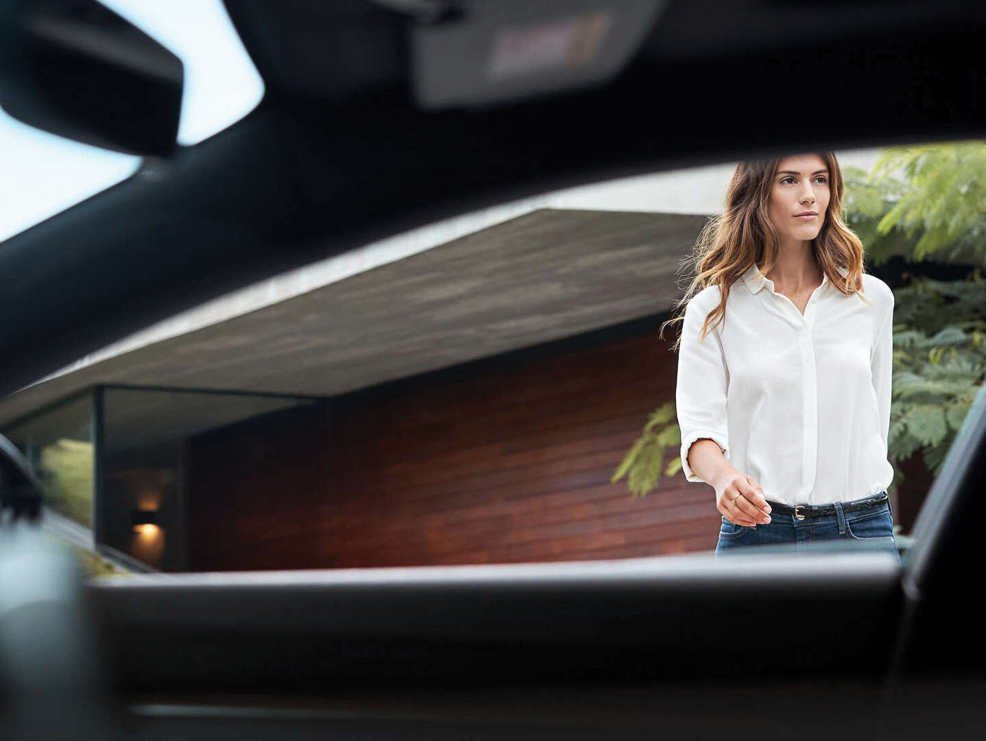 Молода жінка підходить до автомобіля Peugeot